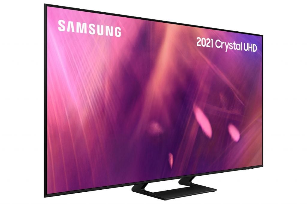 Samsung AU9000 displayA black Samsung UE50AU9000 TV standing on a white background, displaying pink and purple wallpaper with Samsung written on the top left and 2021 Crystal UHD written on the top right, facing right