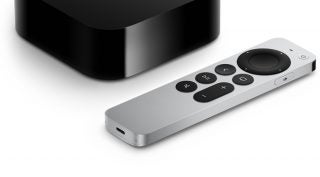 Black Apple TV with a white remote and black buttons on it