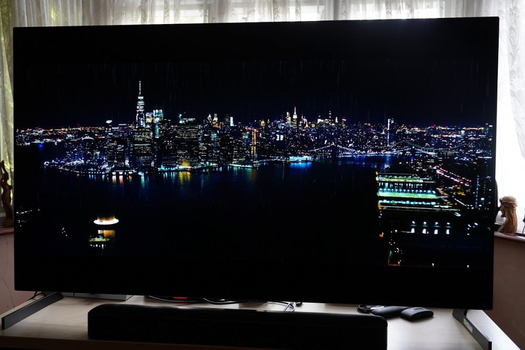 LG G1 OLED TV displaying night scene of a developed modern city from sky