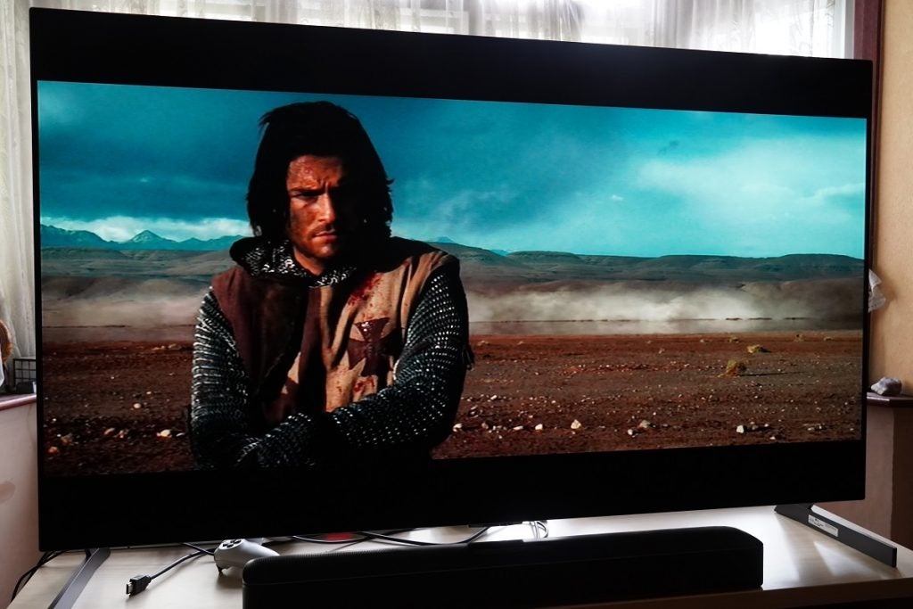 LG G1 OLED TV playing Kingdom, displaying  a man standing in an empty barren open land 