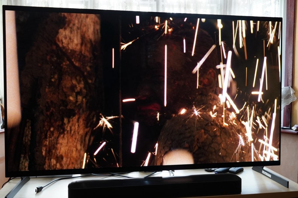 Predator in 4K HDR10 on LG G1 OLEDLG G1 OLED TV playing Predator, displaying  a man standing near a tree, crying, and sparkes falling on him