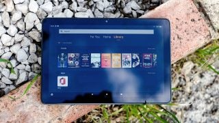 Front view of a blue Fire HD 10 plus tablet with visible library screen and books on it