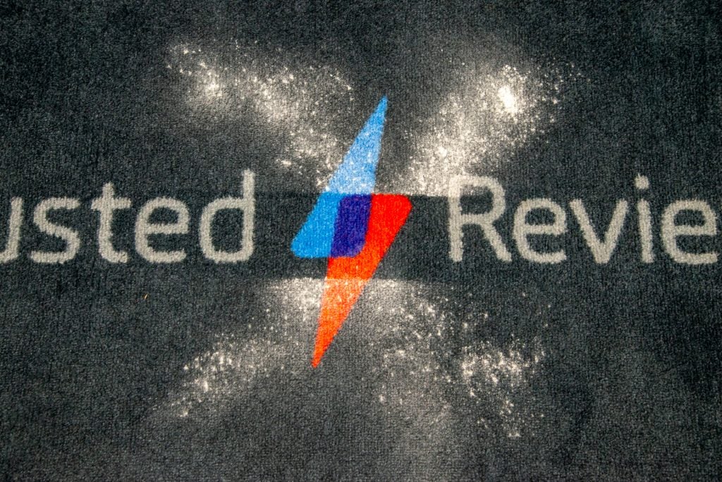 Logo with dust around on a dark carpet surface.Dust pattern on carpet with Trusted Reviews logo.