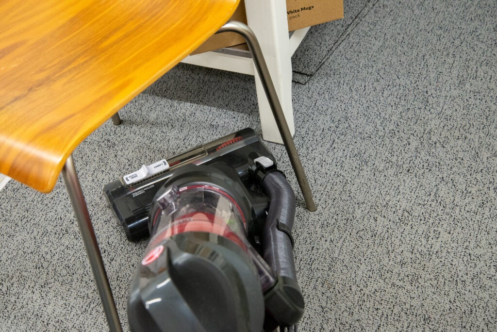 Hoover H-Upright 300 cleaning around a chair
