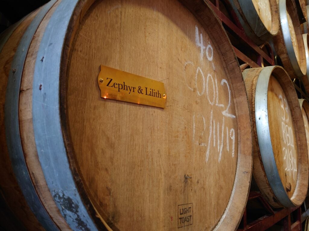 Wooden barrels in a cellar with chalk markings.