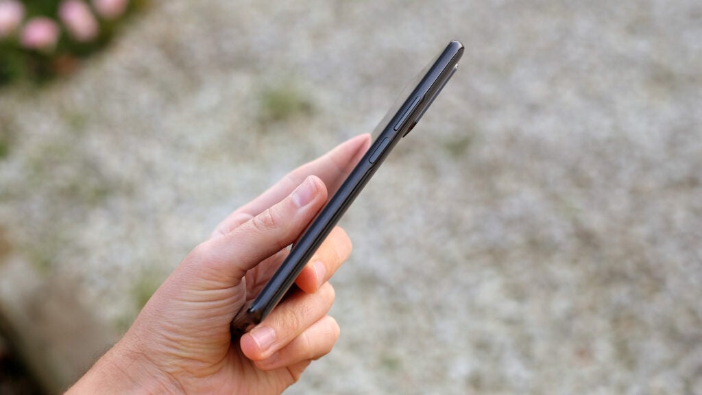 Hand holding Xiaomi 11T Pro smartphone showing its side profile