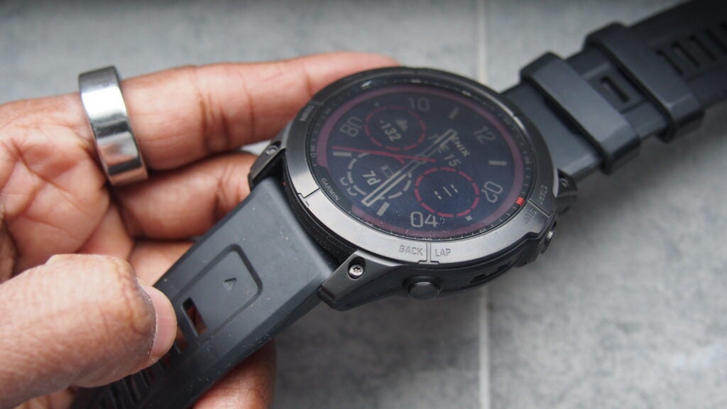 Garmin Fenix 7X held to show the strap and watch face