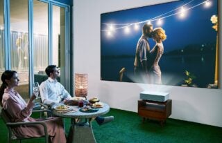 LG CineBeam lifestyle image of projector in a garden