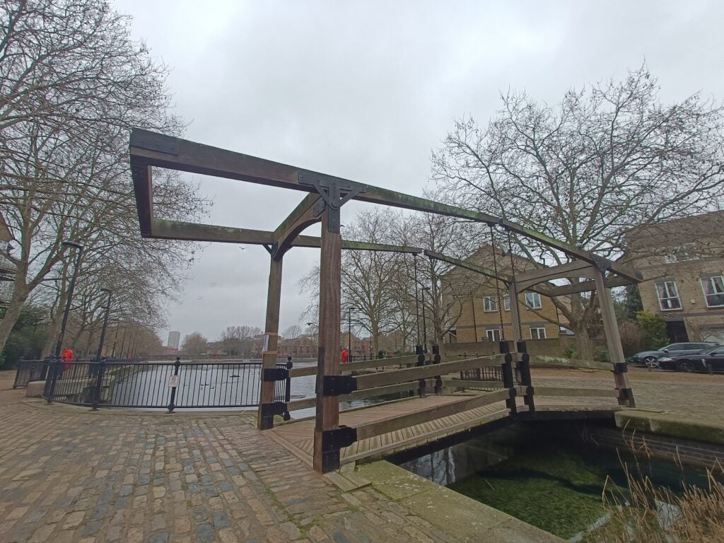 Изображение, сделанное сверхширокоугольной камерой OnePlus Nord CE 2 5G, на котором виден мост через пруд.