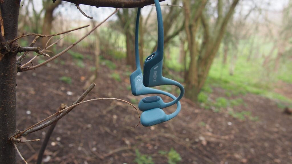 Shokz OpenRun Pro headphones hanging from a tree