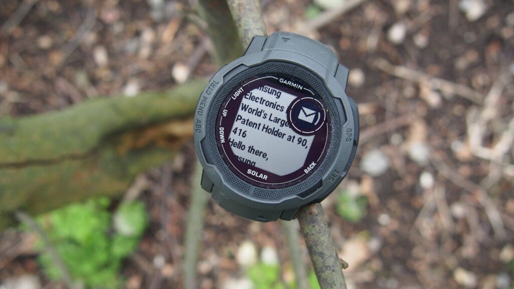 Garmin Instinct 2 showing a message that is open, balanced on branch