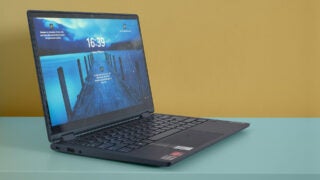 Lenovo Yoga 6 laptop on a teal table against yellow wall.