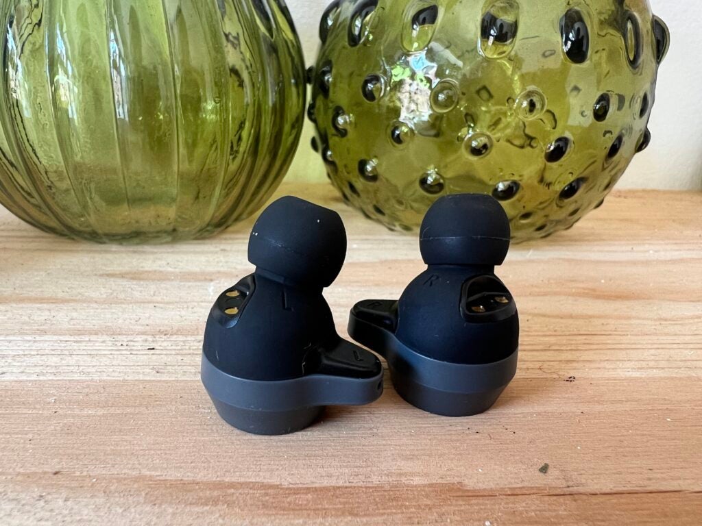 The right and left Cleer Roam NC earbuds sitting on a desk