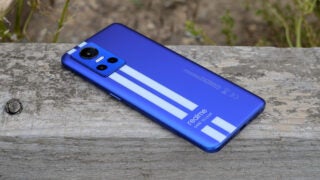 Realme GT Neo 3 smartphone in blue on textured surface.