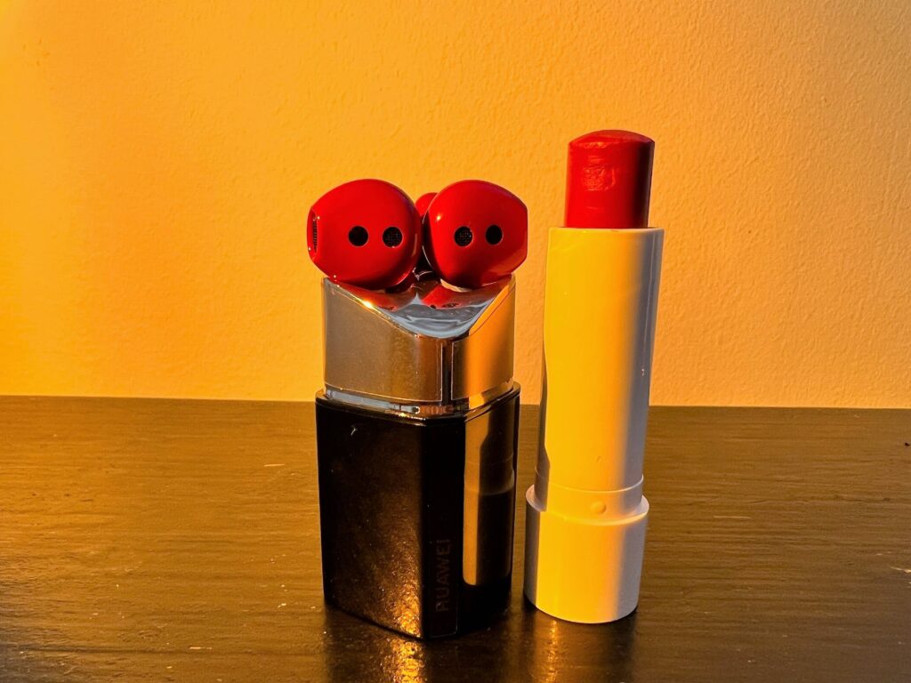The FreeBuds Lipstick next to a lipstick sahde in a similar shade of red