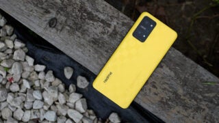 Realme GT Neo 3T smartphone on a wooden plank.