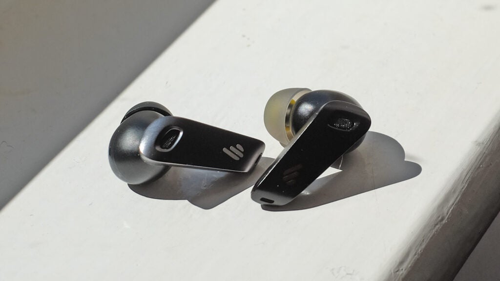 Edifier NeoBuds S earbuds on a sunlit surface.
