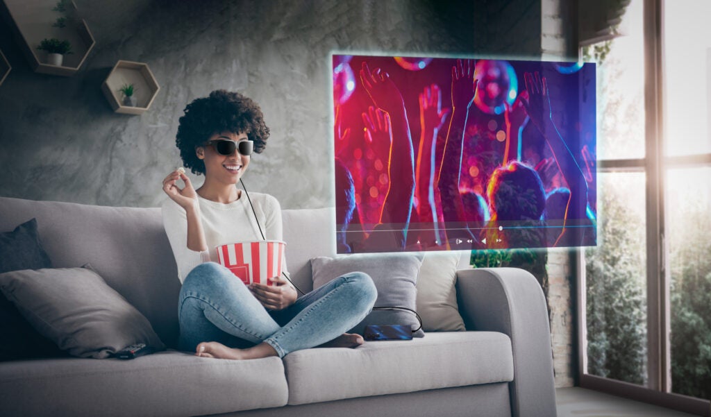 Photo of pretty funny dark skin wavy lady homey mood eating popcorn watching favorite humor television show sitting cozy couch casual sweater jeans outfit flat indoors; Shutterstock ID 1563648814; purchase_order: 1319; job: ; client: Lenovo Glasses T1 Datasheet - Shino; other: