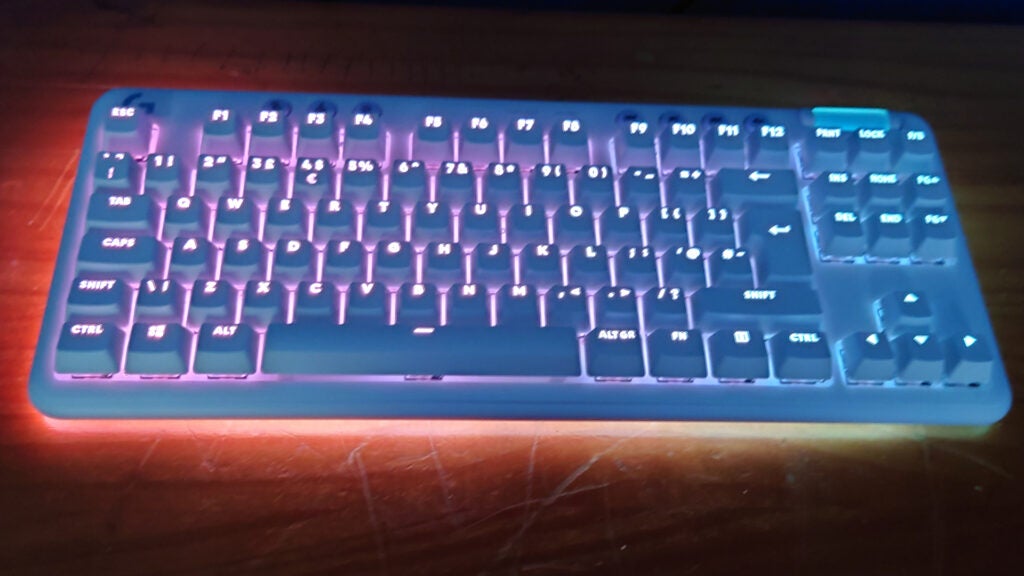 Illuminated Logitech G715 wireless keyboard on a desk.