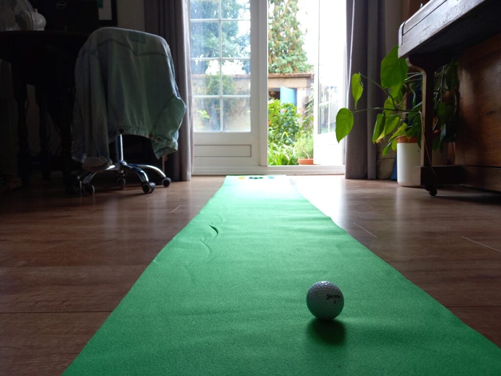 Фотография Samsung Galaxy M22 с мячом для гольфа на коврике, ведущем к окну