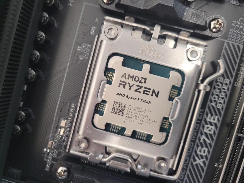 The AMD Ryzen 9 7900X processor placed into the motherboard socket.