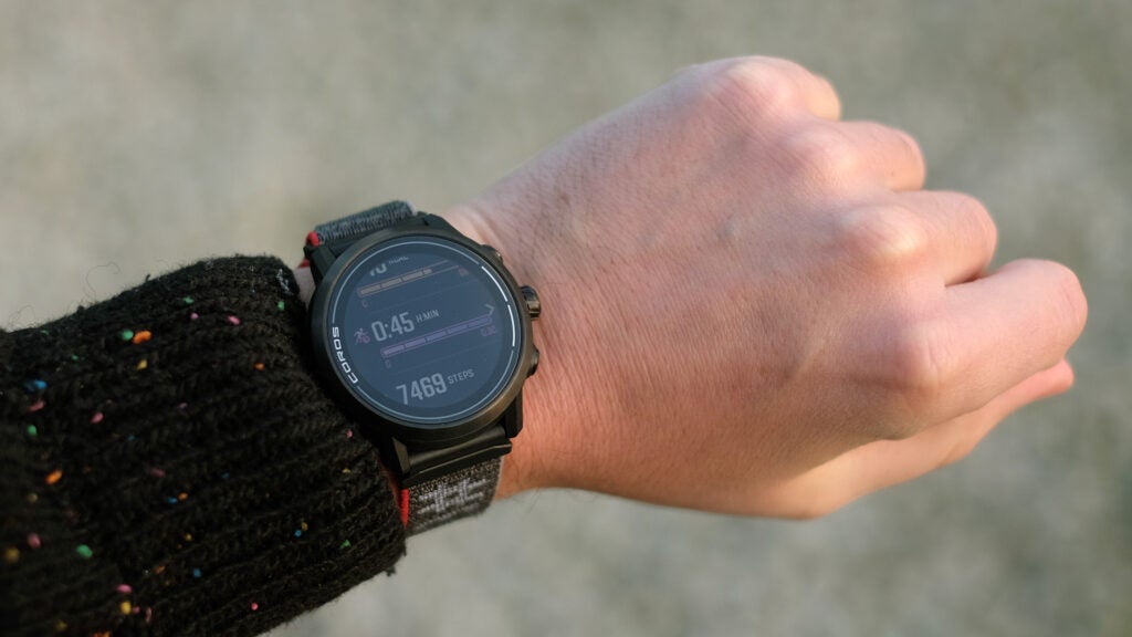 The Coros Apex 2 on a wrist, with its screen showing activity and step count