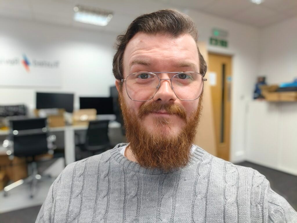 Man with beard in office environment.