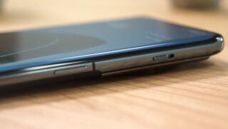 Close-up of a OnePlus 11 smartphone side profile on a desk.