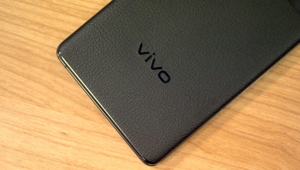 Vivo smartphone with black leather finish on wooden surface