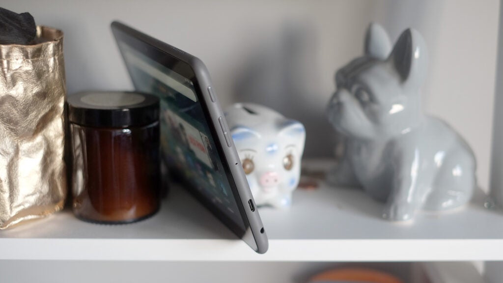 Amazon Fire HD 8 Plus tablet on a shelf with decorative items.