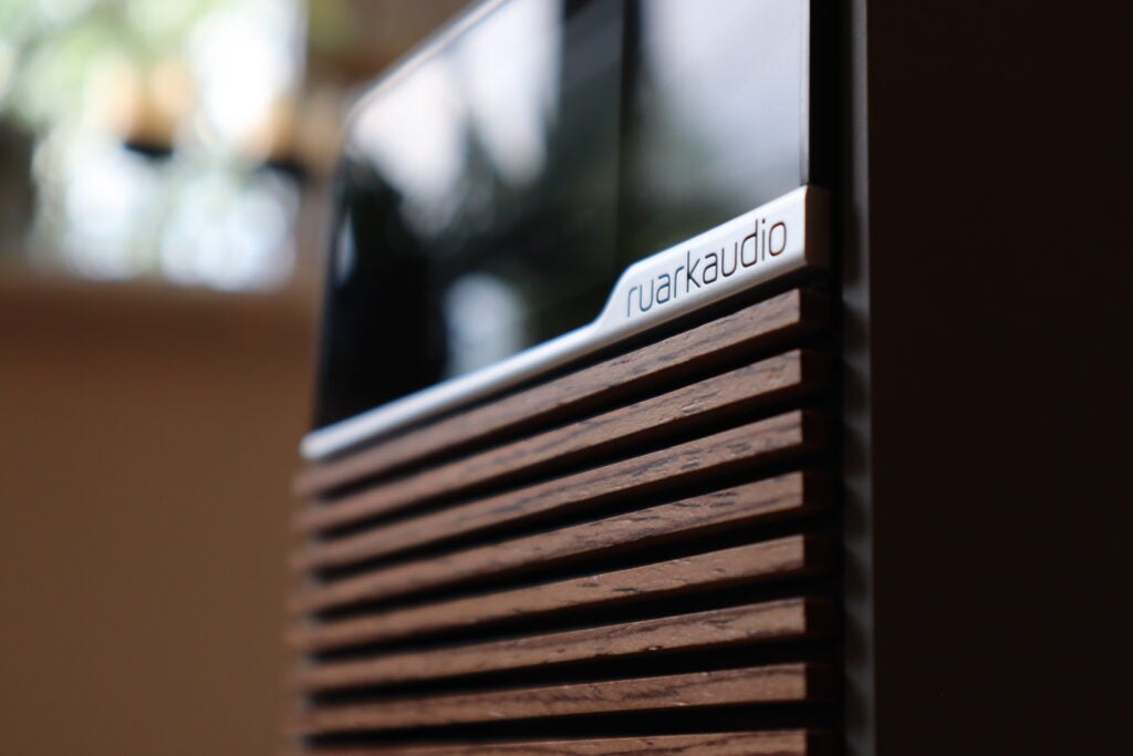 A side-on look at the Ruark R1S logo and the walnut grille
