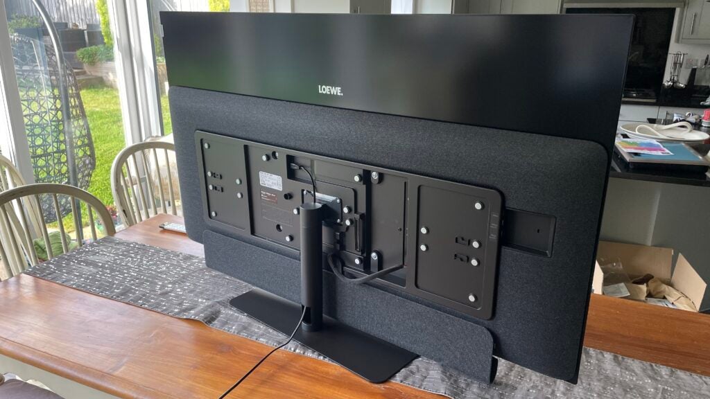 Rear view of the Loewe Bild i.55 with the Klang Bar i attached. Note how the fabric of the optional soundbar matches the fabric applied to the chunky part of deepest section of the TV's rear.
