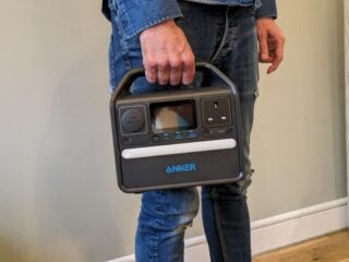Person holding an Anker PowerHouse 521 portable charger