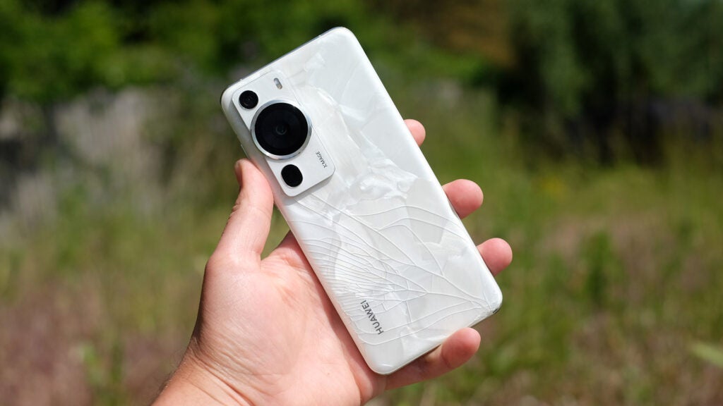Huawei P60 Pro in-hand showing a shattered rear panel