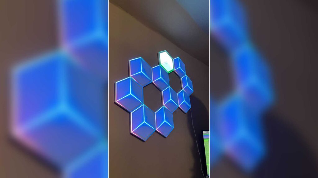 A Govee Glide Hexagon Light Panels Ultra failing to sync with the rest of the set during installation.Govee Glide Hexagon Light Panels on wall in blue tones.