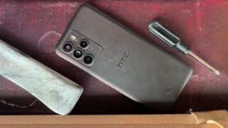 HTC U23 Pro on a desk with a screwdriver and other tools