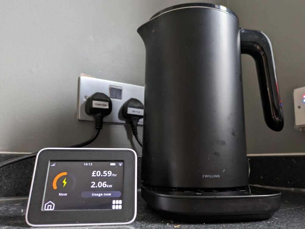 A smart meter display next to a kettle
