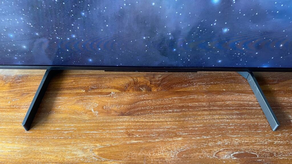 Detail view of the Sony 65X95L's feet in their central position.Sony XR-65X95L TV on wooden surface displaying space image.