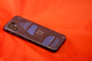 Fairphone 5 smartphone on orange background.