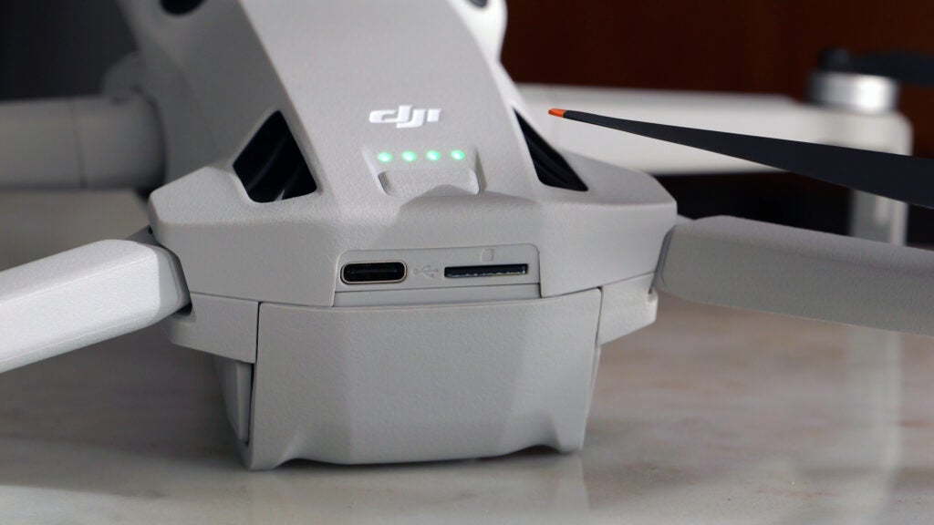 Front ports on the DJI Mini 4 ProClose-up of DJI Mini 4 Pro drone showing battery indicator and ports.