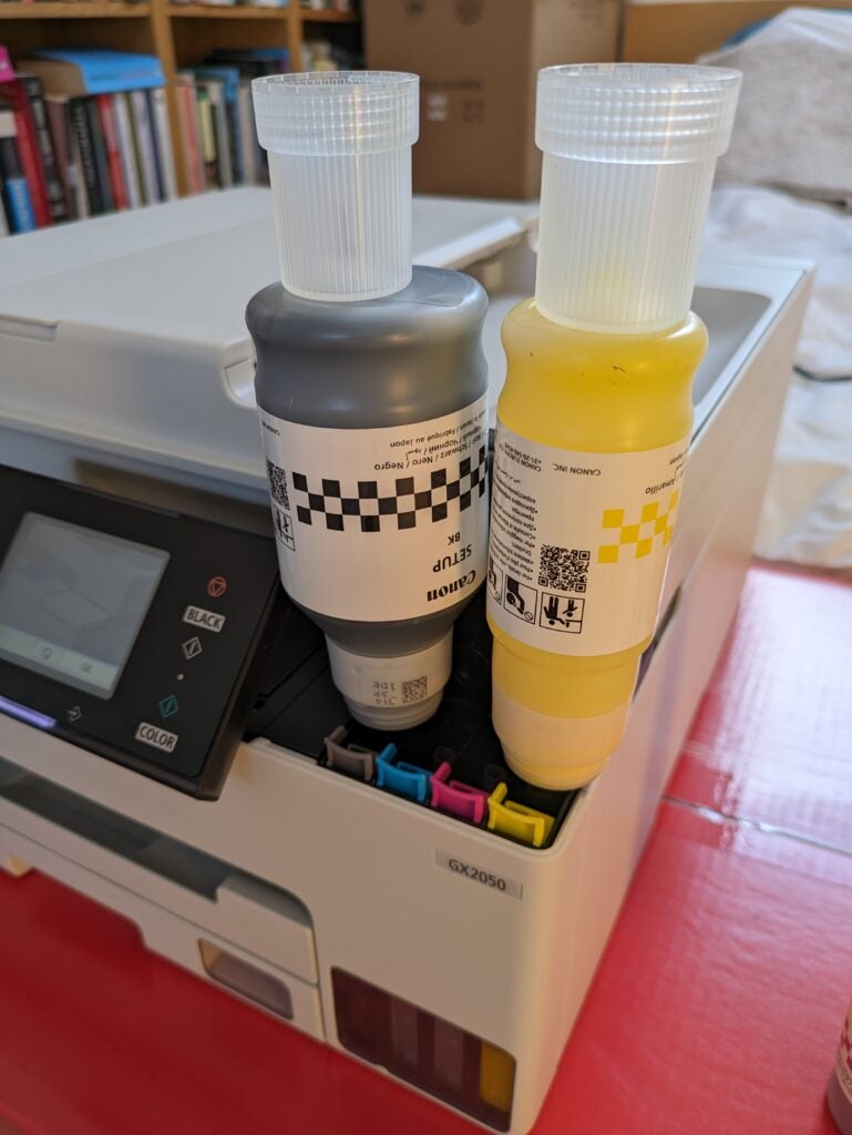 Black and yellow ink bottles filling the printer
