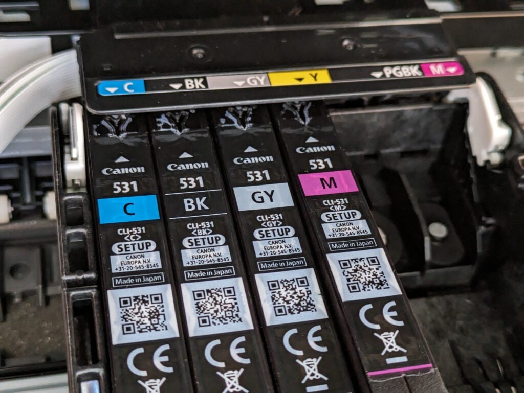 Shot of the ink cartridges, showing the magenta cartridge partially inserted into the yellow slot