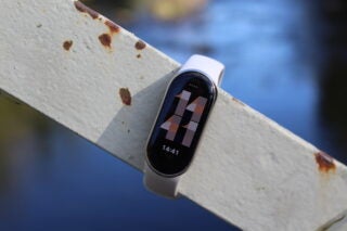 Xiaomi Smart Band 8 on rusty metal surface displaying time.