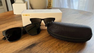 The AJ01 smart sunglasses with their box and case.