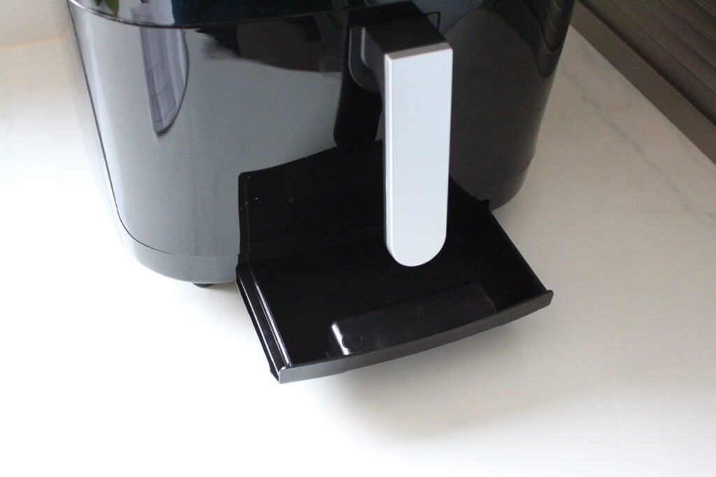 Salter XL Digital Steam Air Fryer drip traySalter Air Fryer with open drawer on kitchen counter.