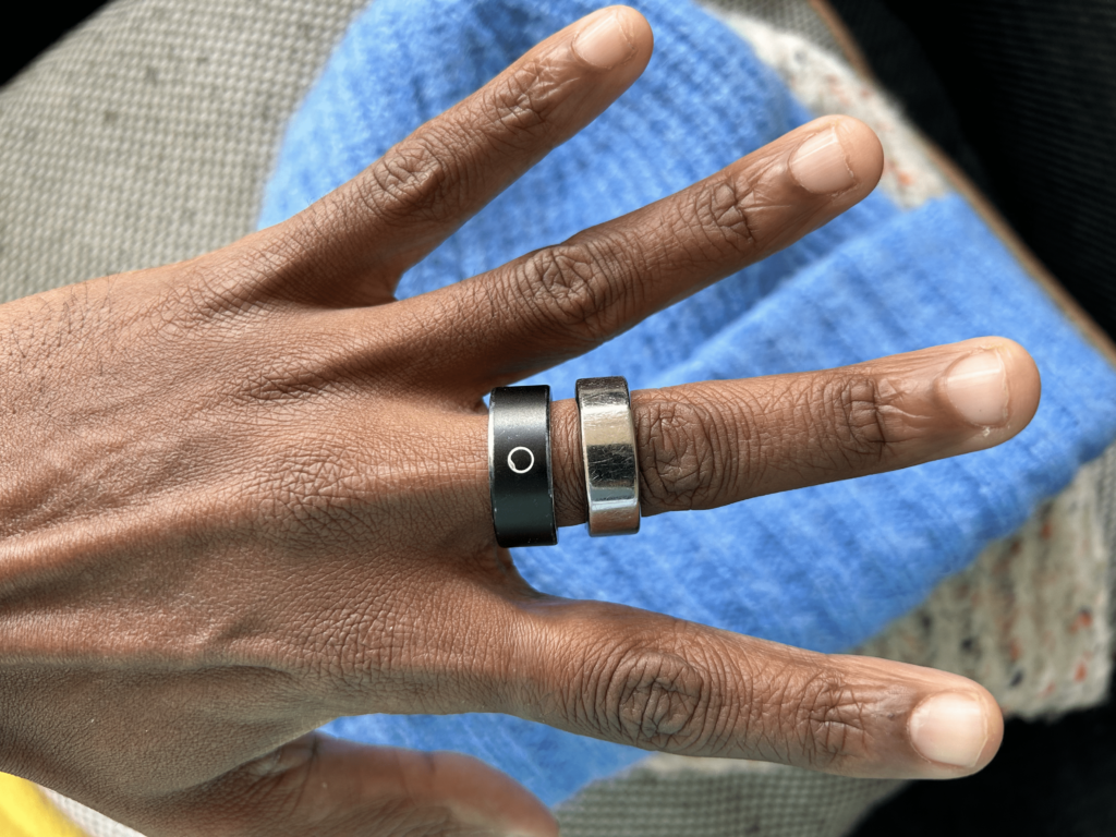 Circular Smart Ring Slim on finger next to Oura RingCircular Smart Ring displayed on a textured fabric surface.