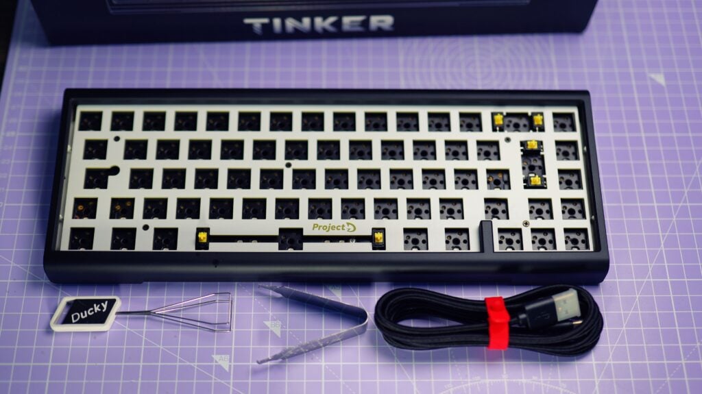 Ducky ProjectD Tinker 65 Barebones keyboard on desk with accessories.