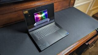 Razer Blade 16 laptop on a black mat with screen on.
