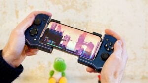 Hands holding Turtle Beach Atom mobile gaming controller with a game on screen.