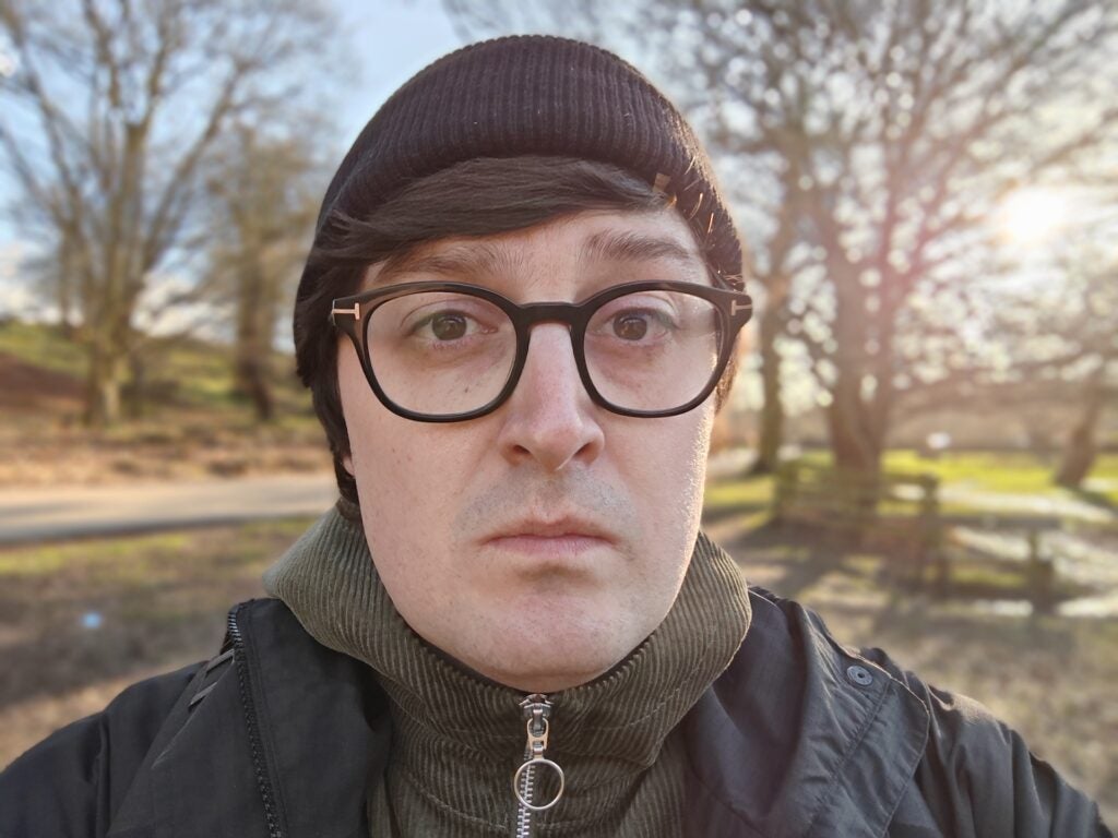 Honor Magic V2 RSR Porsche Design selfie camera sampleMan in beanie and glasses with blurred park background.